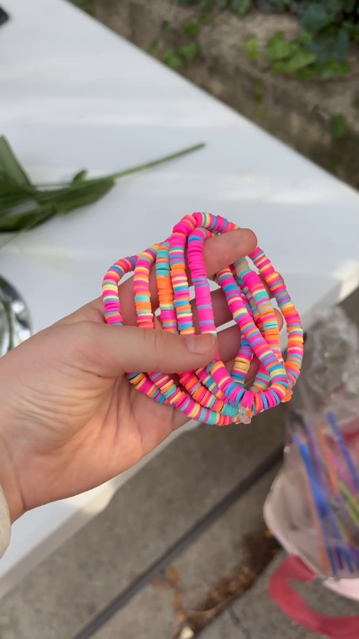 A close-up of Camila’s colorful handmade bracelets held together at the bracelet stand